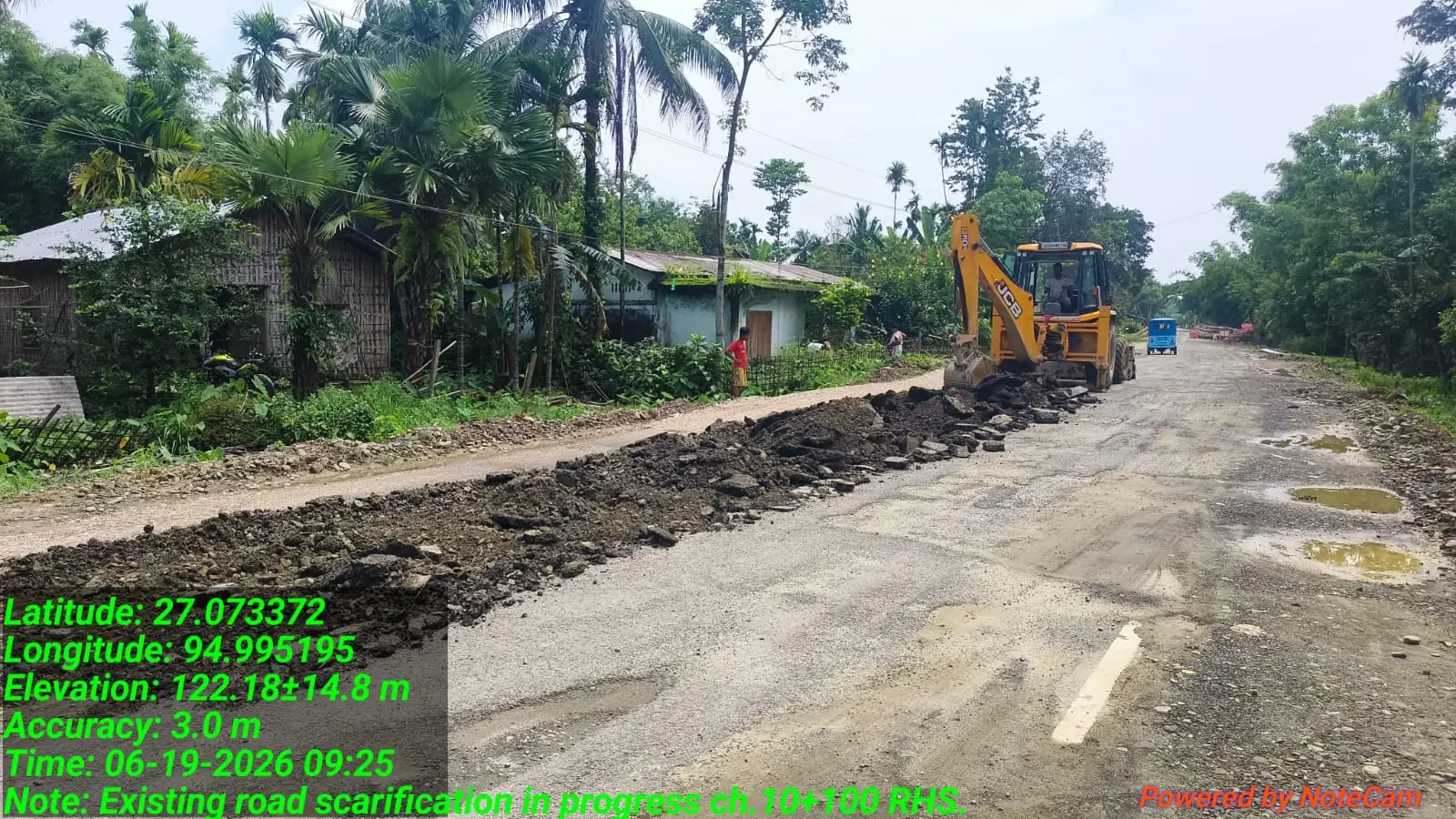 Backhoe loader on road works, Assam